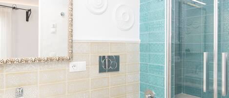 A bathroom with a sink, mirror, and shower.