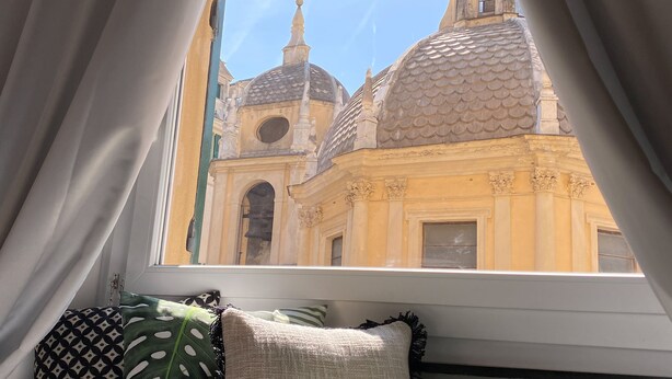 Janela com vista para um edifício de arquitetura em cúpula.