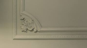A wall with a decorative molding and a floral design.