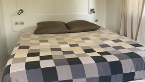 A bedroom with a checkered bedspread, a white headboard, and a pendant light. - Nature lovers by the sea (Bormes-les-Mimosas)