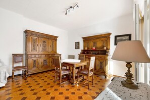 Un coin repas avec une table et des chaises en bois, une lampe et une vue sur l’extérieur.