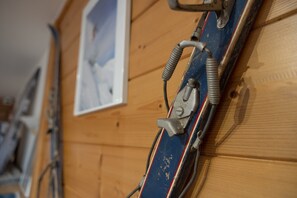 Un mur en bois avec un porte-skis et un tableau encadré.