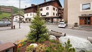 Un hôtel de style architectural alpin traditionnel, caractérisé par une façade en bois remarquable et un balcon.