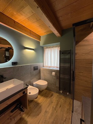 A modern bathroom with a wooden ceiling, a large mirror, a sink, a toilet, and a shower area. - Baita Miralago - Salient with Mountain Views, Shared Garden, and Wi-Fi (Livigno)