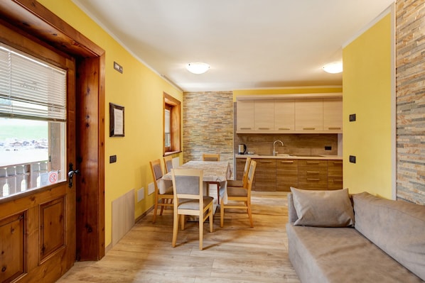 Un espace de vie compact comprenant un coin repas, une kitchenette et un canapé.