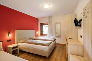 Une chambre à coucher avec un lit, des tables de chevet, un miroir et une fenêtre.