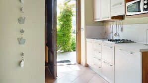 Una cocina con armarios blancos, un microondas y una estufa a gas.