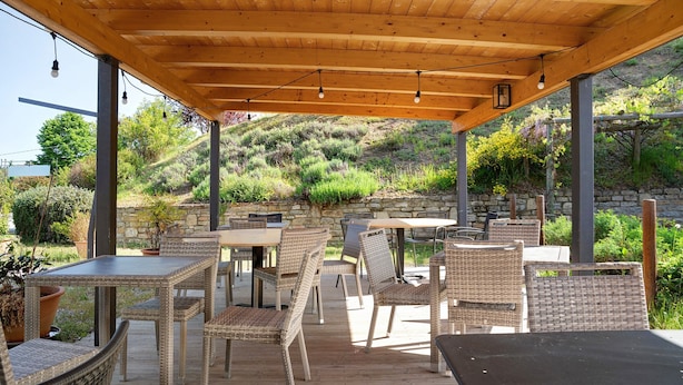 Un patio al aire libre con mobiliario de mimbre y techo de madera.