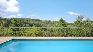 Una piscina con vistas a una ladera boscosa.
