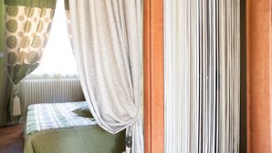 Una habitación con cama, radiador y cortinas.