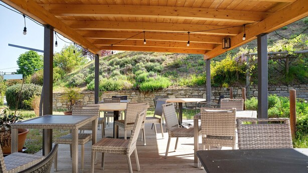 An outdoor patio with wicker furniture and a wooden ceiling.