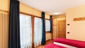 Une pièce avec un lit, un radiateur et une porte en bois.