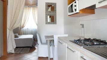 Een koelkast, een microgolfoven, een kookplaat, een kinderstoel