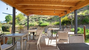 Une terrasse extérieure avec des meubles en osier et un plafond en bois.