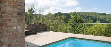 Una piscina con vistas a una ladera boscosa.