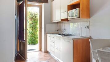 Een koelkast, een microgolfoven, een kookplaat, een kinderstoel