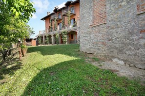 Un cortile con un edificio caratterizzato da porticati ad arco e una facciata in mattoni.
