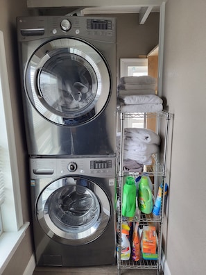 Convenient laundry facilities with two front-loading washing machines and storage for essentials.
