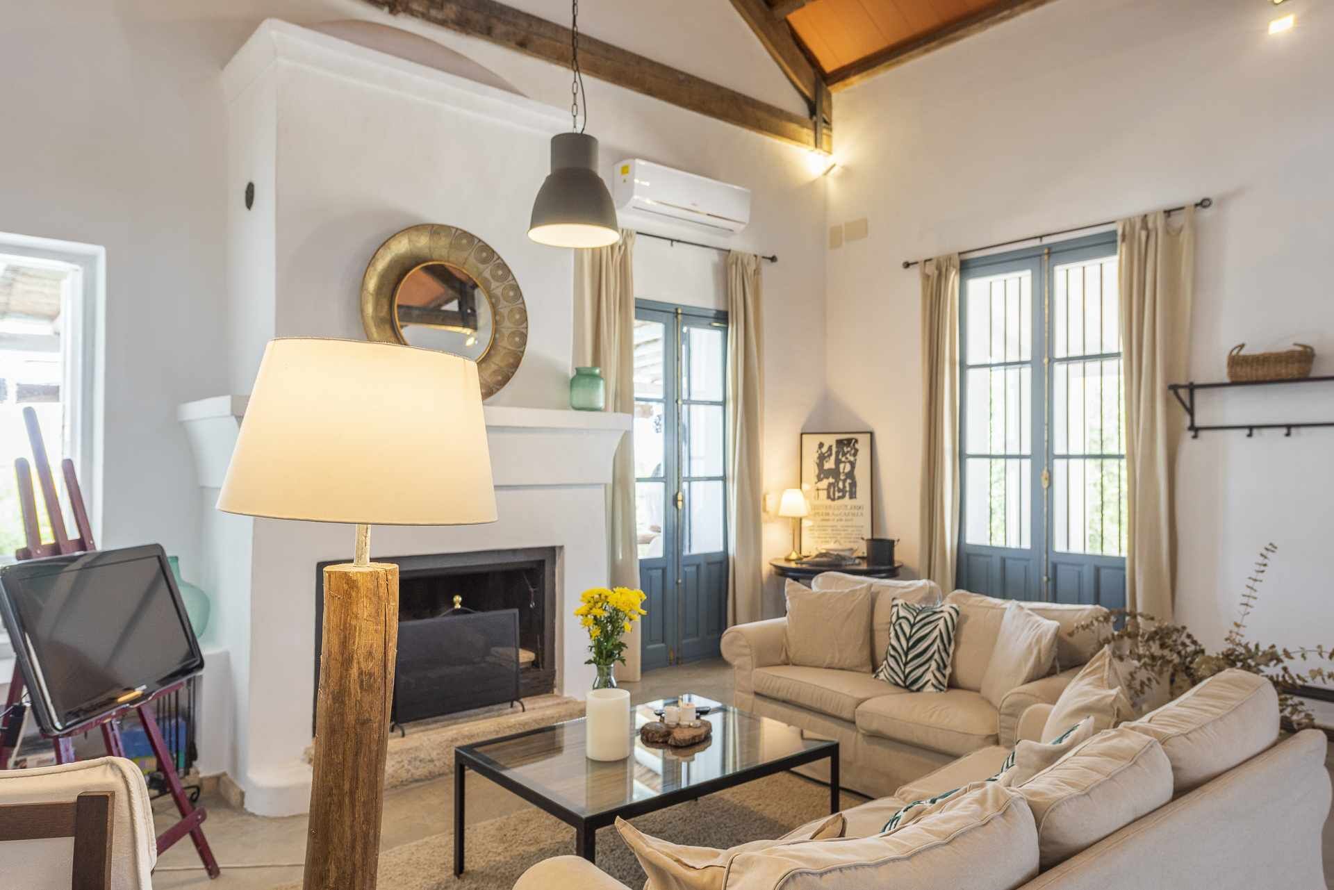 Un salon avec une cheminée, un canapé, une table basse et une lampe.