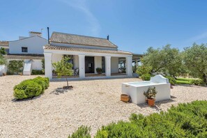 Un bâtiment blanc avec un toit en tuiles et un patio couvert.