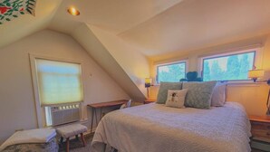 A bedroom with a large bed, two bedside tables, a window with blinds, a radiator, a bench, and a small table. - 5 Suite in 1820`s house Open Hearth Inn (Trenton)