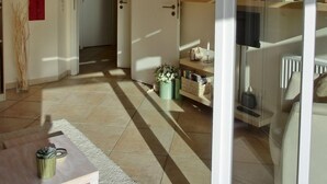 Un espacio habitable amplio con un sofá, una mesa de centro y una puerta de cristal que da a la cocina.