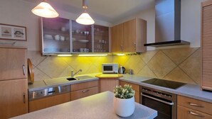 Una cocina moderna con armarios de madera, microondas integrado, un fregadero y una estufa.