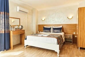 Ein Hotelzimmer mit einem hölzernen Bett, einem Nachttisch mit Lampe, einem Kleiderschrank und einem Spiegel.