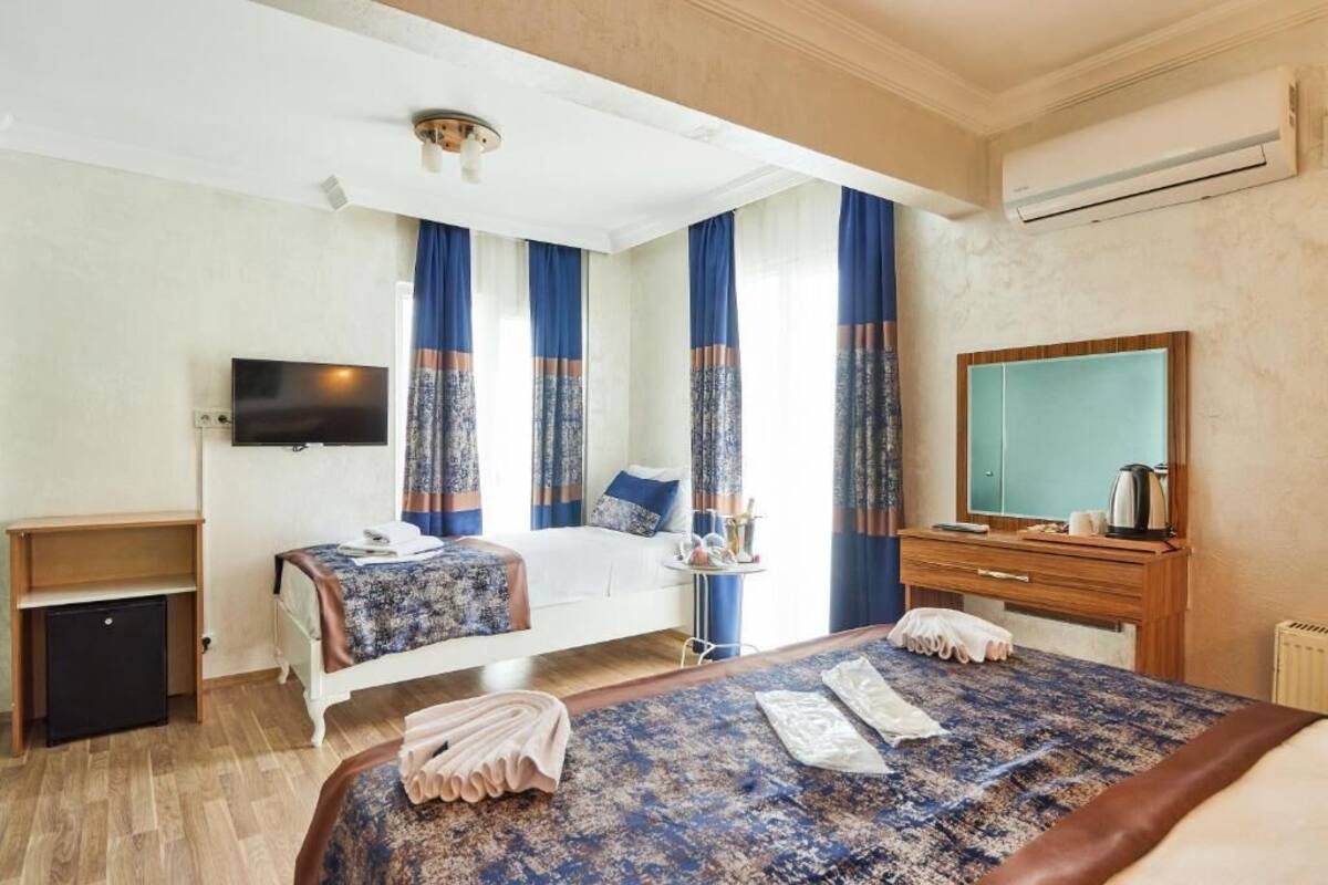 A hotel room with a bed, a desk, a TV, and a mirror.