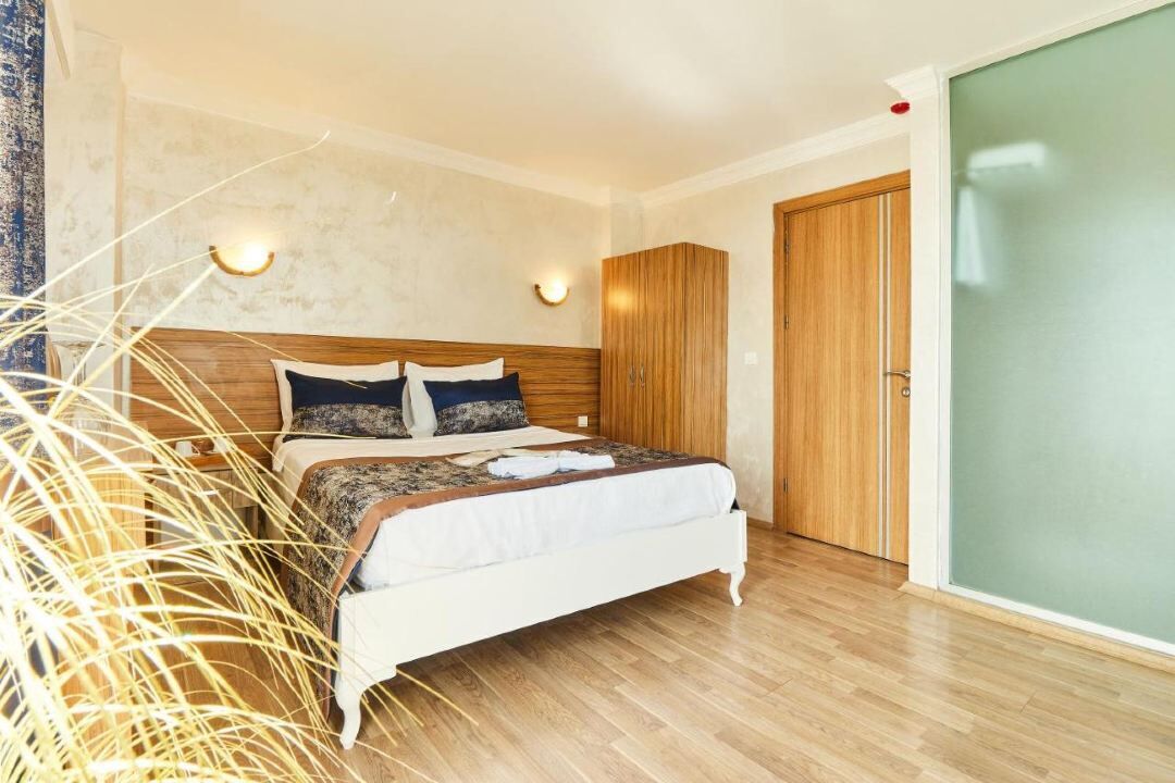 A bedroom with a wooden bed, a wardrobe, and a sliding door.