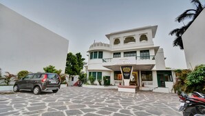 A hotel with a sign reading "Hotel & Restaurant" and "The Legal House" below. It features a multi-story building with a stone-paved courtyard. - Treebo The Regal House, Near Fateh Sagar Lake (Udaipur)