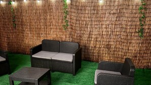 A room with wicker furniture, including a sofa and two armchairs, on a green carpet. - Apartment terrace WIFI cable channels 4 pers Lille fac de droit Moulins (Lille)