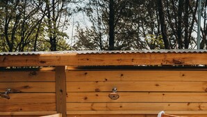 A wooden sauna with a bench and a towel hanging on the door.