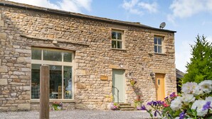A stone building with a large window, a door, and a satellite dish. - Ingleborough View (Carnforth)
