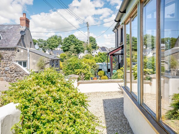 Un quartier résidentiel avec des maisons en pierre, un jardin et un ciel dégagé.