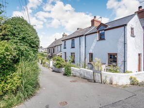A narrow street lined with white houses, some with visible chimneys and windows, and a sign reading "ORCHARD ROW". - Sea Pickle Cottage (Haverfordwest)