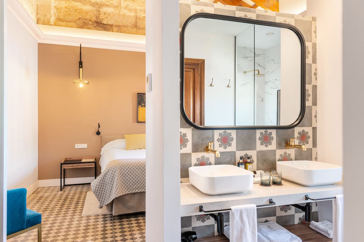 Een moderne badkamer met een grote spiegel, twee wasbakken en een douche.