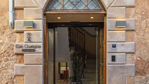 The entrance to Can Ouetglas Boutique Hotel with a stone facade, a glass door, and a staircase leading inside. - Hotel Can Quetglas - Adults Only +14 (Palma de Mallorca)