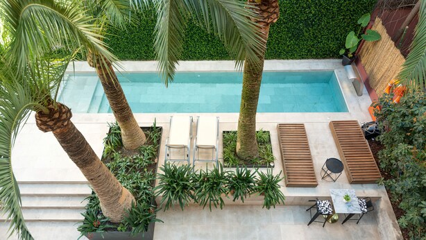 A rooftop pool area with lounge chairs, a table, and potted plants. - Hotel Can Quetglas - Adults Only +14 (Palma de Mallorca)