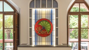 A reception desk with a stained glass window above it and a sign that reads "Can Quetglas". - Hotel Can Quetglas - Adults Only +14 (Palma de Mallorca)