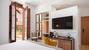 A hotel room with a bed, a desk with a chair, a television, and a large mirror. - Hotel Can Quetglas - Adults Only +14 (Palma de Mallorca)