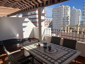 A balcony with a tiled table, chairs, and a small potted plant. - Stunning penthouse apartment near the ocean with a view. Parking and Terrace (Torre del Mar)