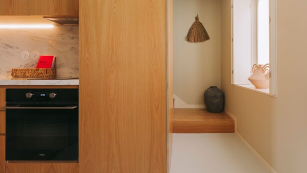 A modern kitchen with wooden cabinets, a black oven, and a marble countertop. - Village Aparthotel by BOA (Porto)