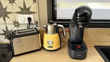 A kitchen counter with a toaster, a yellow Klarstein electric kettle, and a Krups electric coffee maker.