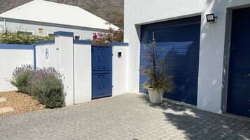Stunning mountain views surround this charming property, featuring a decorative metal gate and beautifully landscaped garden.