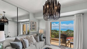 Una sala moderna con sofá, mesa de centro y vistas al exterior.