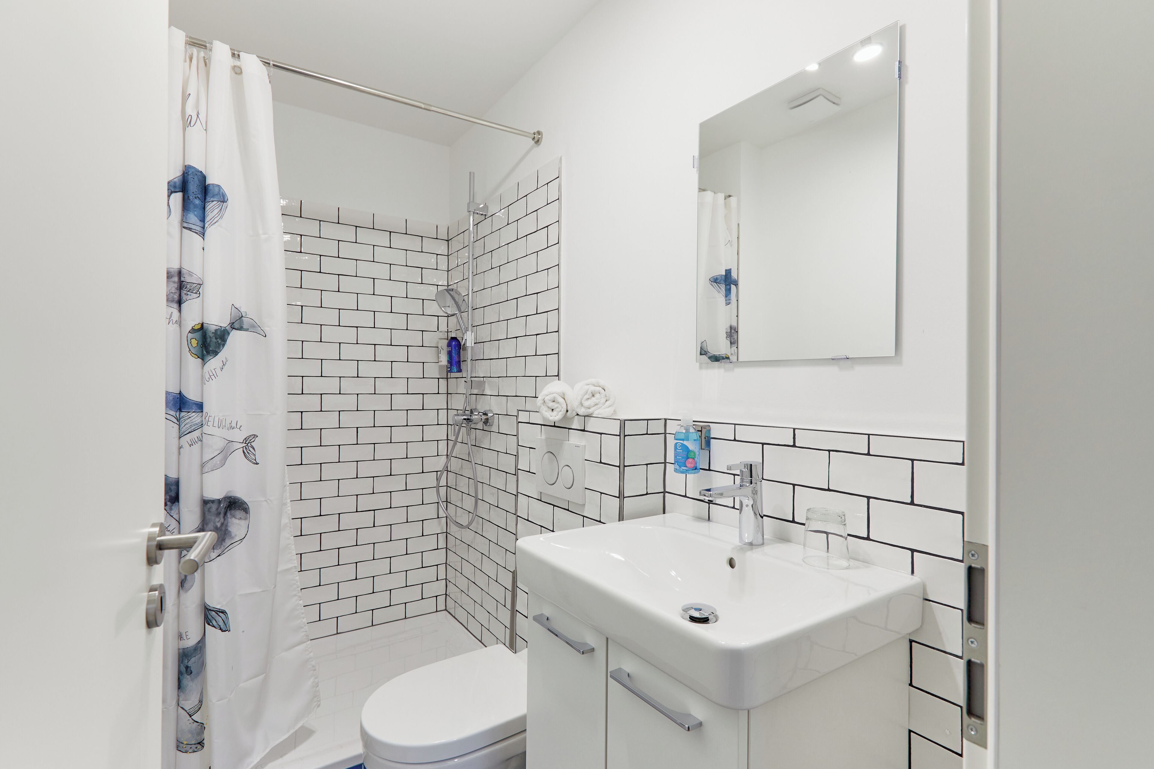 A bathroom with a shower, toilet, and sink.