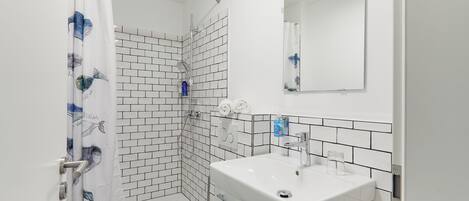 A bathroom with a shower, toilet, and sink.