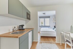 Una cocina moderna con encimera de madera, pileta de acero inoxidable y microondas integrado.