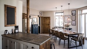 A modern kitchen with a central island, wooden accents, and a dining area with a large table set for six. - Rheinfreunde Bingen das Ferienhaus für Viele (Bingen am Rhein)